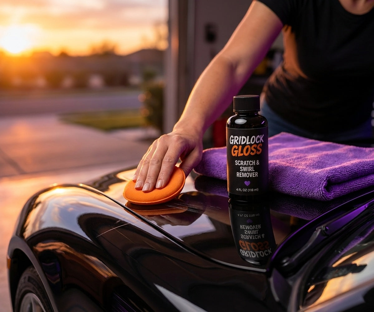 Confident woman applying Gridlock Gloss to a lightly scratched classic car in a garage.